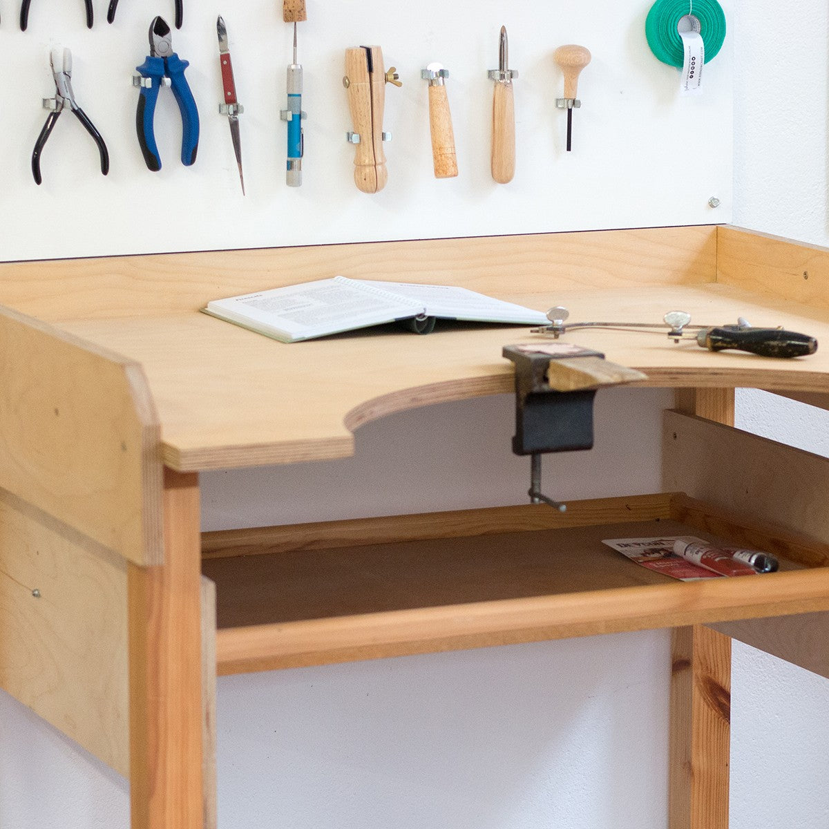 Jeweler's workbench with hand tools hung above it