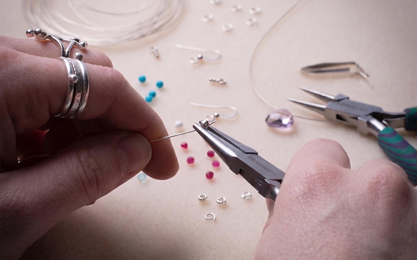 A collection of essential jewelry repair tools and supplies including pliers, adhesives, and findings for fixing broken jewellery at home.
