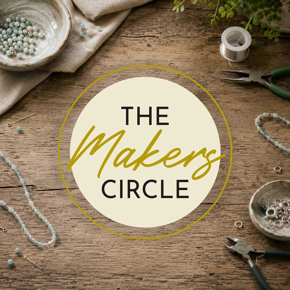 Rustic jewellery making workspace with pliers, beads and jewellery-making tools on a wooden craft table.